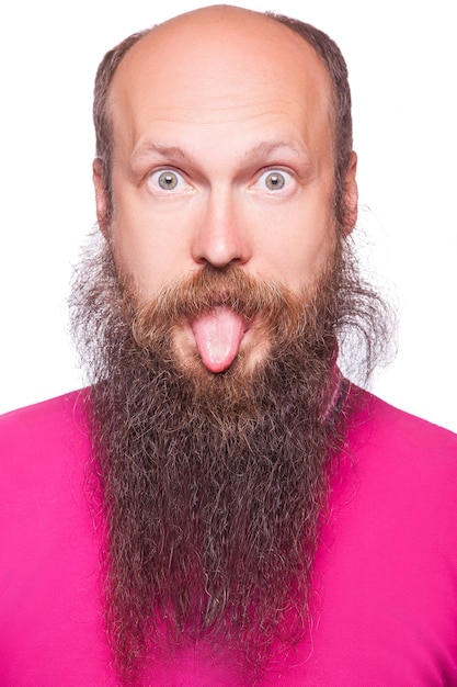 Foto retrato de um jovem careca, barbudo engraçado mostrando a língua, a expressão do rosto.
