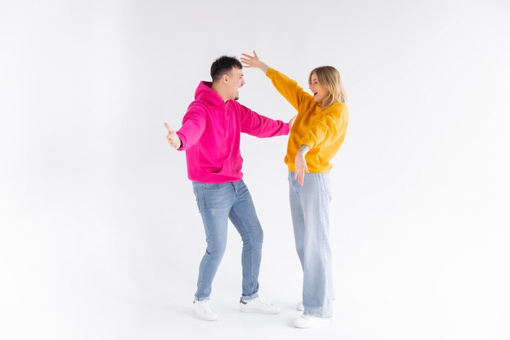 Retrato de um jovem casal alegre usando capuzes isolados sobre fundo branco ok gest