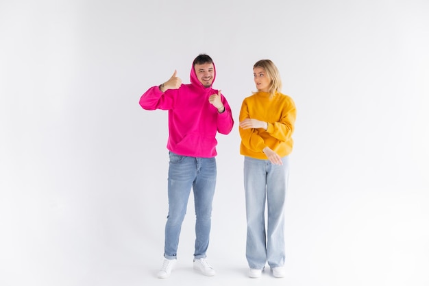Retrato de um jovem casal alegre usando capuzes isolados sobre fundo branco ok gest