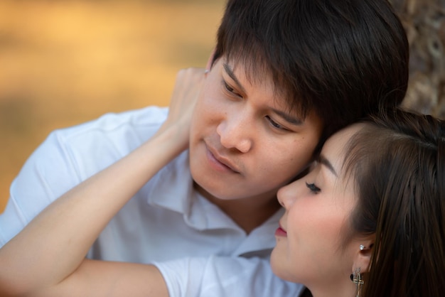 Retrato de um jovem casal asiático apaixonado na florestaTailândia pessoas felizes por estarem juntosConceito de dia dos namorados