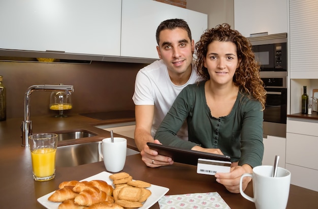 Retrato de um jovem casal com tablet eletrônico e compra com cartão de crédito na internet. Conceito de compras online.