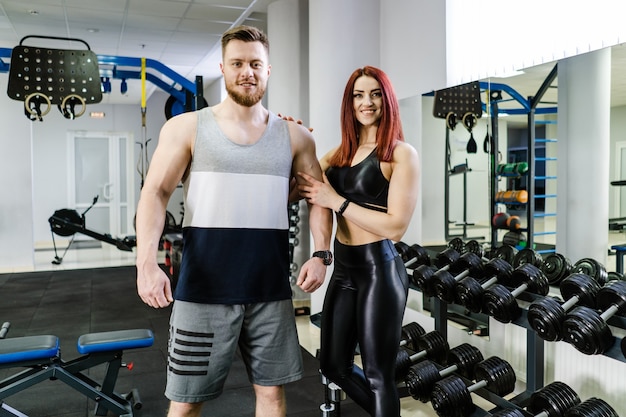 Retrato de um jovem casal em forma de pé no estúdio de fitness