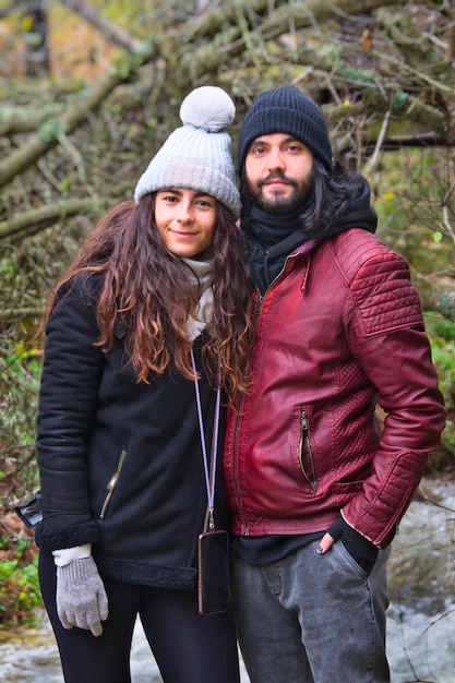 Retrato de um jovem casal em roupas de inverno e chapéus posando olhando para a câmera.