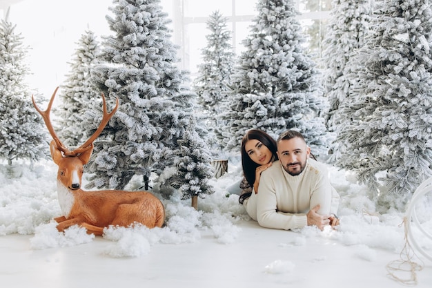 Retrato de um jovem casal em sua sala de estar perto da árvore de natal