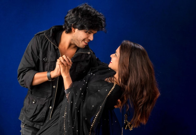 Retrato de um jovem casal feliz e alegre posando em fundo escuro Homem e mulher atraentes sendo brincalhões