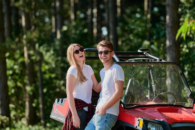 retrato de um jovem casal feliz e animado desfrutando de um lindo dia ensolarado enquanto dirigia um carro de buggy off road na natureza montanhosa