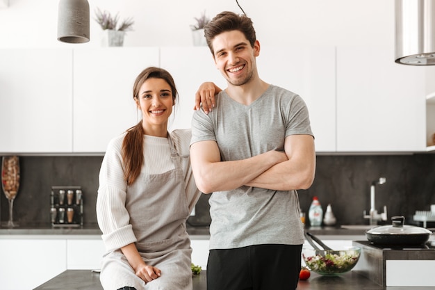 Retrato de um jovem casal feliz na cozinha