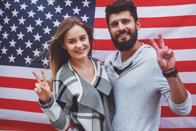 Retrato de um jovem casal feliz no fundo da bandeira dos EUA