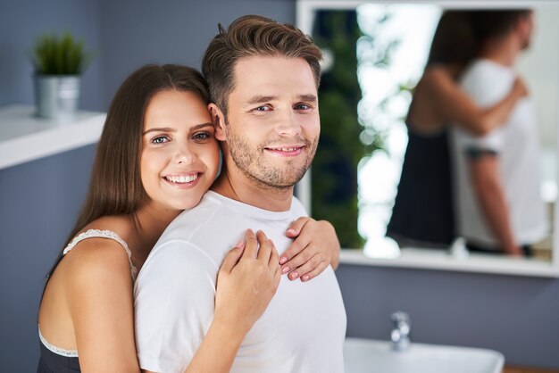 Retrato de um jovem casal feliz se abraçando no banheiro