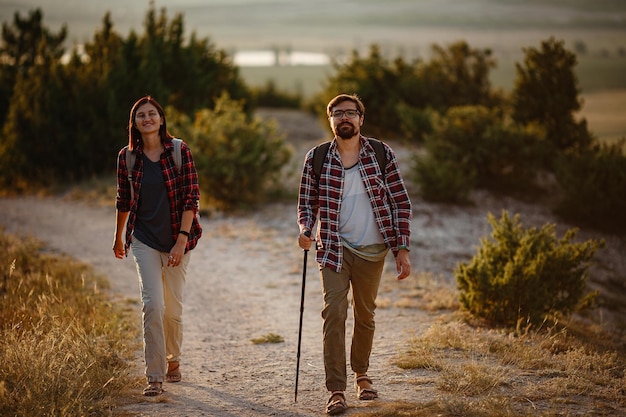 Retrato de um jovem casal feliz se divertindo em sua viagem de caminhada Casal de caminhantes caucasianos e asiáticos se divertindo nas férias de verão