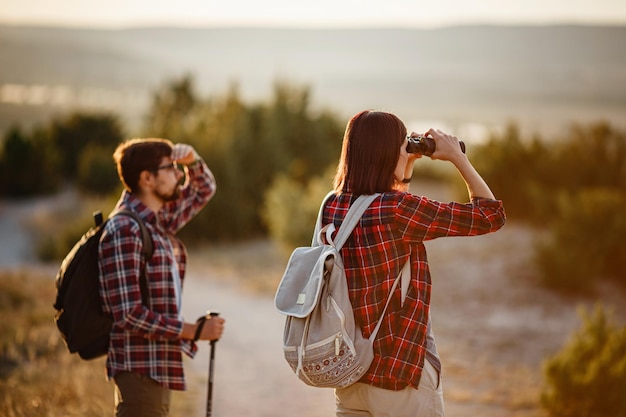 Retrato de um jovem casal feliz se divertindo em sua viagem de caminhada Casal de caminhantes caucasianos e asiáticos se divertindo nas férias de verão