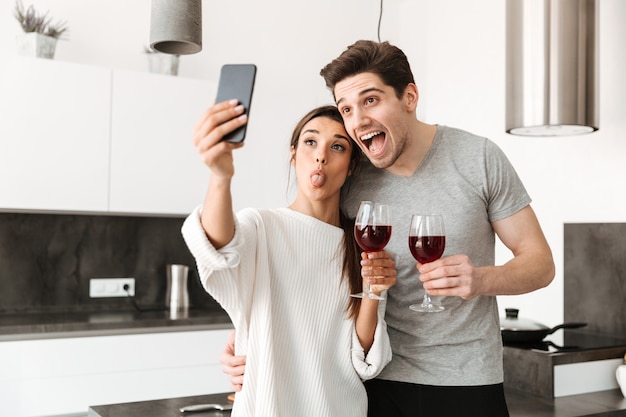 Retrato de um jovem casal feliz, tomando uma selfie