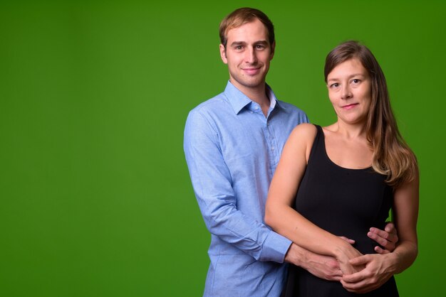 Retrato de um jovem casal junto à parede verde