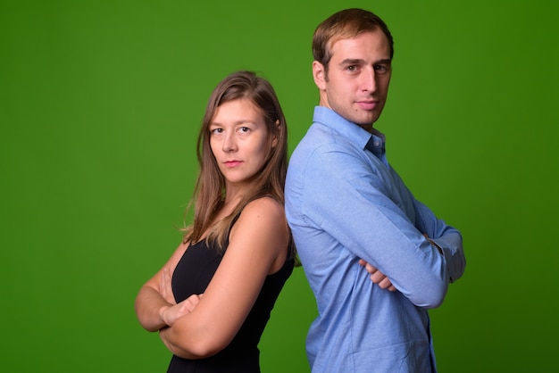 Retrato de um jovem casal junto à parede verde