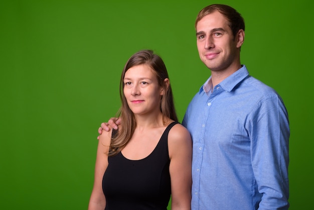 Retrato de um jovem casal junto à parede verde