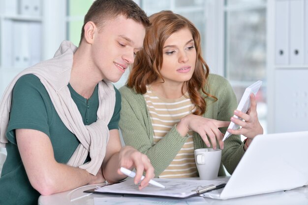 Retrato de um jovem casal lindo com um laptop