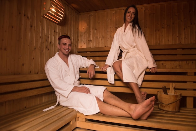 Retrato de um jovem casal lindo feliz gosta de relaxar na sauna