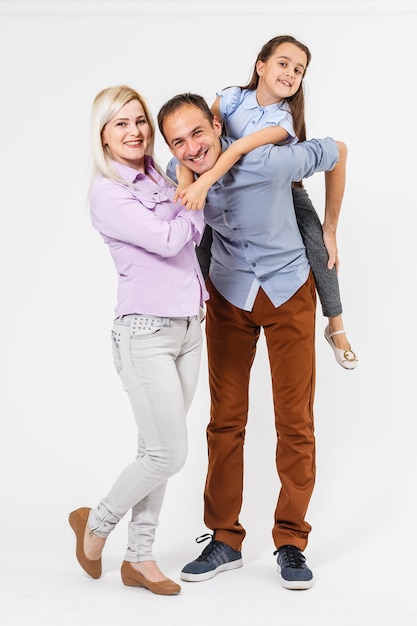 Retrato de um jovem casal se divertindo com sua filha. Isolado em um fundo branco.