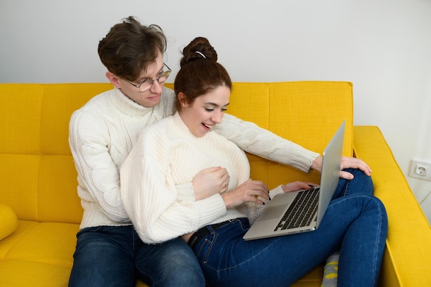 Retrato de um jovem casal sorridente usando laptop em casa foto de alta qualidade interna