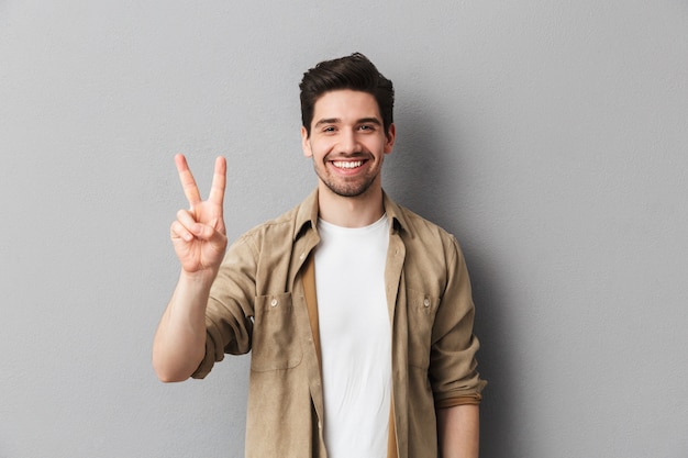 Retrato de um jovem casual feliz mostrando paz