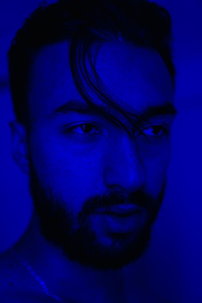 Retrato de um jovem com sardas olhando para o lado foto vertical de luz azul