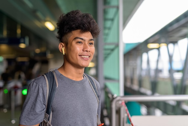 Foto retrato de um jovem de pé contra o corrimão