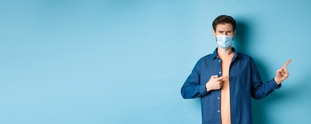 Foto retrato de um jovem de pé contra um fundo azul