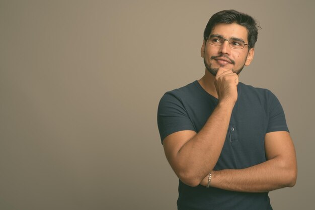 Foto retrato de um jovem de pé contra um fundo cinzento