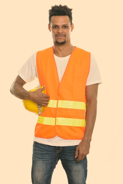 Foto retrato de um jovem de pé contra um fundo laranja