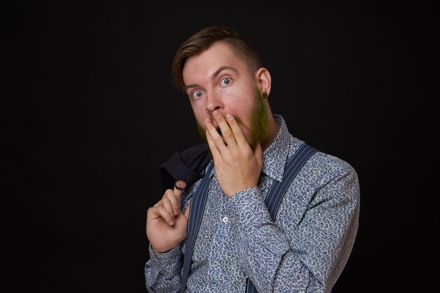 Foto retrato de um jovem de pé contra um fundo preto