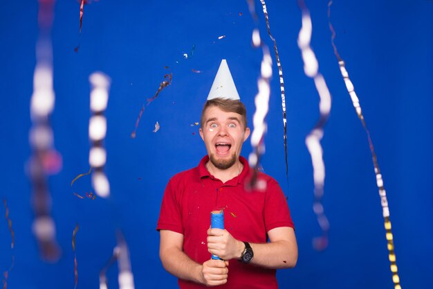 Retrato de um jovem de pé contra uma parede azul