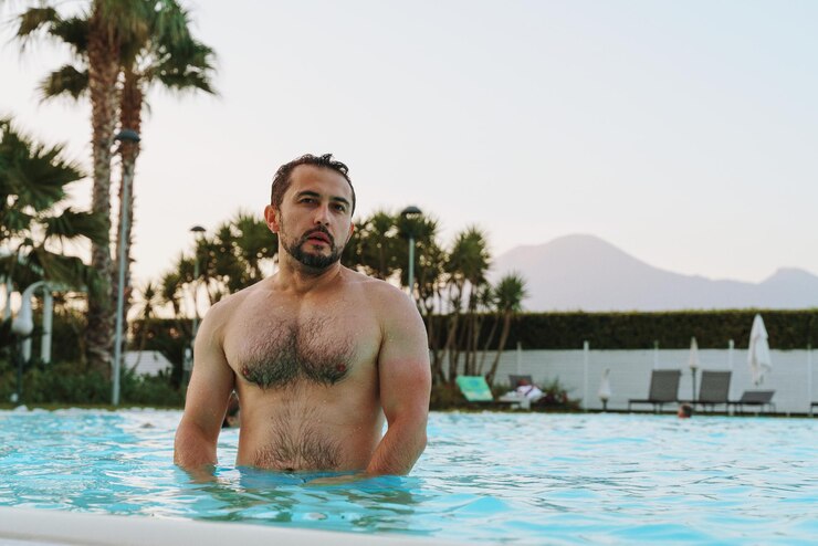 Foto retrato de um jovem de pé na piscina