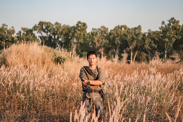 Retrato de um jovem de pé no campo contra o céu
