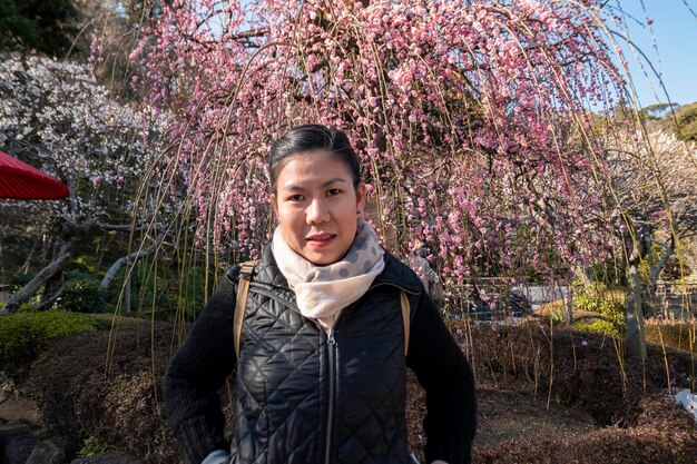 Foto retrato de um jovem de pé perto de uma flor de cerejeira