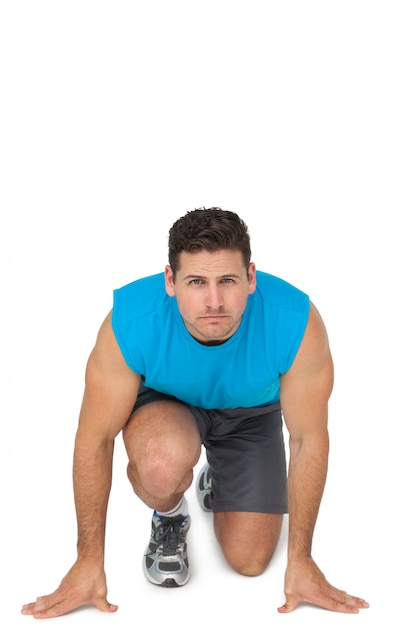 Foto retrato de um jovem desportivo em posição de corrida