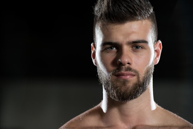 Retrato de um jovem desportivo no ginásio moderno com equipamento de exercício