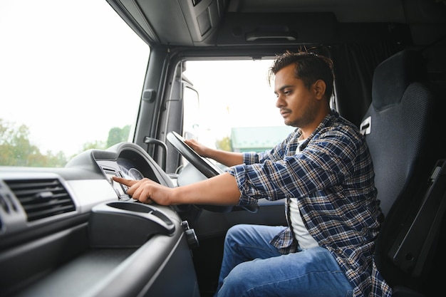 Retrato de um jovem e bonito motorista de caminhão indiano O conceito de logística e transporte de mercadorias