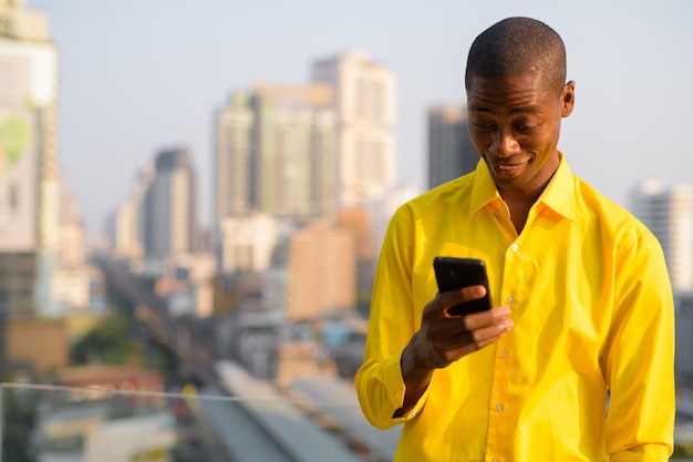 Retrato de um jovem empresário africano careca contra a vista da cidade
