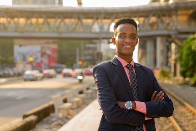 Retrato de um jovem empresário africano de sucesso, usando terno e gravata, com os braços cruzados