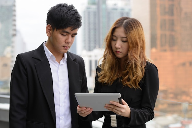 Retrato de um jovem empresário asiático e uma jovem empresária asiática juntos no exterior da cidade