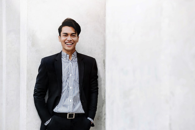 Retrato de um jovem empresário asiático sorridente em um terno casual.