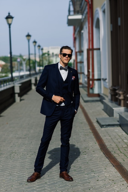 Retrato de um jovem empresário atraente no espaço urbano, vestindo terno e gravata.