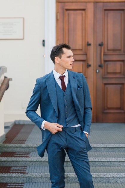 Retrato de um jovem empresário atraente no meio urbano, usando terno e gravata.