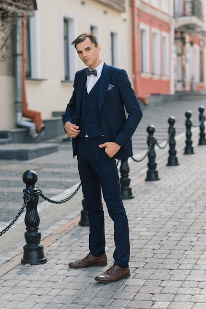 Retrato de um jovem empresário atraente no meio urbano, usando terno e gravata.