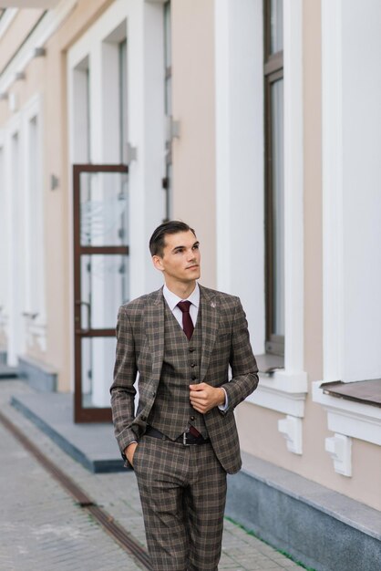 Retrato de um jovem empresário atraente no meio urbano, usando terno e gravata.