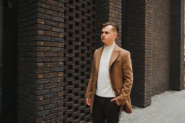 Retrato de um jovem empresário atraente no meio urbano, vestindo terno uma gravata.