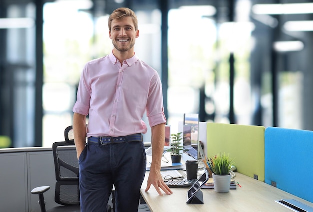 Retrato de um jovem empresário casual feliz no escritório