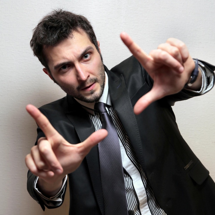 Foto retrato de um jovem empresário confiante fazendo gestos contra a parede