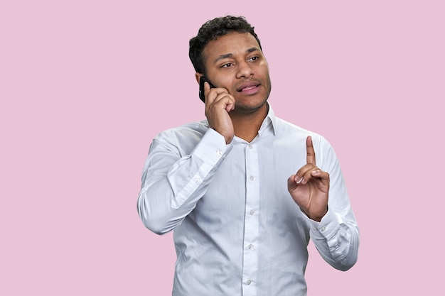 Retrato de um jovem empresário indiano conversando por telefone