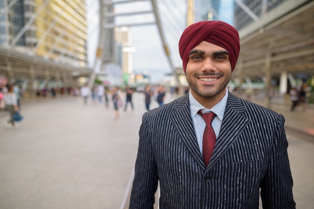 Retrato de um jovem empresário sikh indiano usando turbante enquanto explora a cidade de Bangkok, Tailândia
